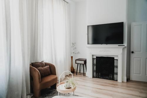 a living room with a fireplace with a tv above it at Your home on Smith St Collingwood Melbourne with parking in Melbourne