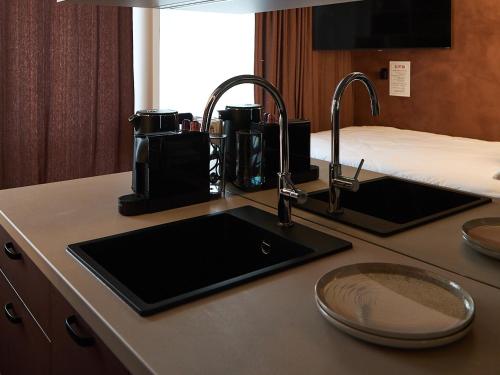a kitchen counter with a sink and a coffee maker at Żurawia Mini Apartments by Sofija in Warsaw