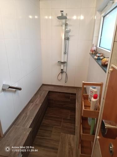 a shower in a bathroom with a wooden floor at Haus Nähe Flughafen und Messe in Düsseldorf