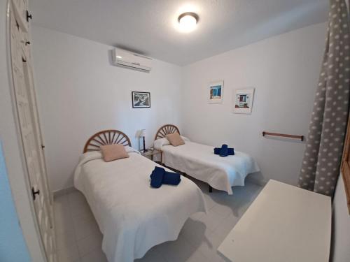 twee bedden in een kamer met witte muren bij PINOS 20 MENYBER in Nerja
