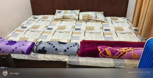 a bed with blankets and pillows on it at Family Room Bed Size 8x6 in Ujjain