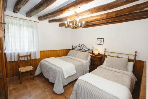 Dos camas en una habitación con paredes de madera. en Rural Casa Caravaca, Bajo, Campo San Juan, Moratalla, en La Risca