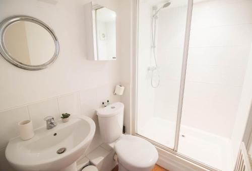 une salle de bains blanche avec toilettes et lavabo dans l'établissement Sunset Beach House By Air Premier, à Seaford