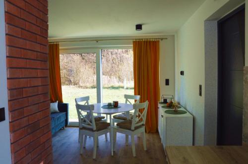 a dining room with a table and chairs and a window at Domek Ranczo Podkówka 