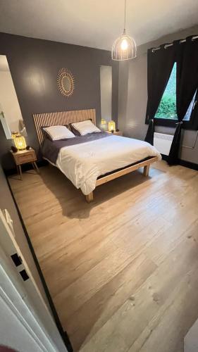 a bedroom with a large bed and wooden floors at Les dunes le Lima in Quend-Plage
