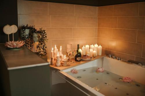 Un baño con bañera con velas y encimera en Bliss insolite Jacuzzi privée 5 min centre ville, en Mulhouse