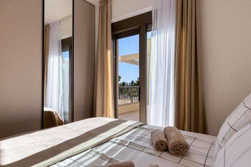 Un dormitorio con una cama con vista a un balcón. en Seaside Cozy Apartment, en Boreti