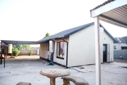 a white building with a table in front of it at Lapeng Mogwase Free Parking-Free WIFI in Mogwase