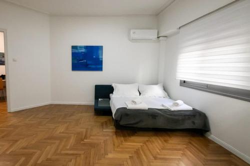 a bedroom with a bed with a window and a wooden floor at Comfy 2BR Flat in Central Athens in Athens
