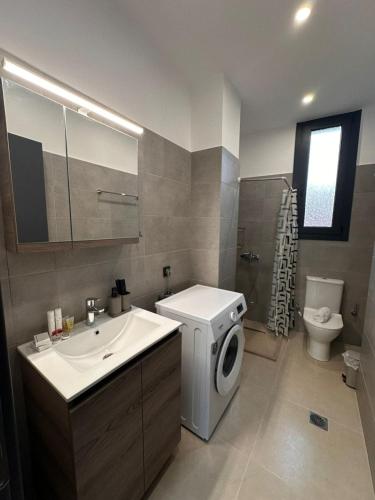 a bathroom with a sink and a washing machine at Helios 2 in Chios
