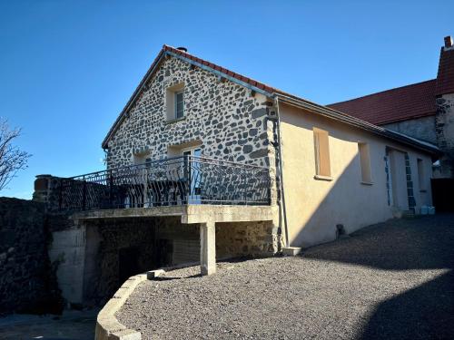 ein Gebäude mit einem Balkon an der Seite in der Unterkunft Gîte Les Aubracs - Puy de Dôme - Massif du Sancy in Saurier