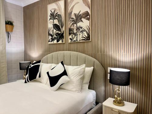 a bed with black and white pillows in a bedroom at Torri Studios in Sliema
