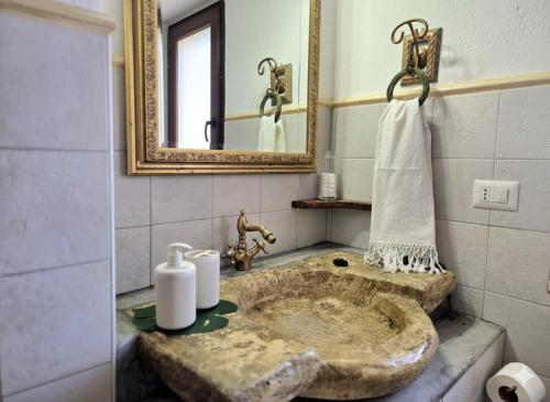 a bathroom with a stone sink and a mirror at S'Arrosa de Monti in Villaputzu