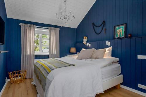 a bedroom with blue walls and a large bed at Modern 4BR Summerhouse with Sauna and Hot Tub in Selfoss