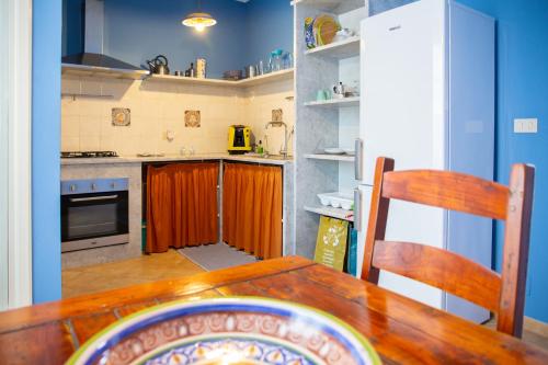 eine Küche mit Holztisch und Kühlschrank in der Unterkunft Solemar Sicilia - Casa Enza in Santa Flavia