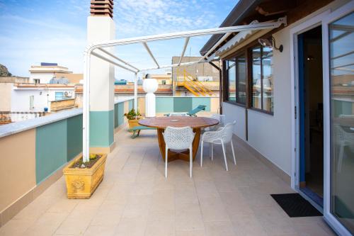 a patio with a table and chairs on a balcony at Solemar Sicilia - Casa Enza in Santa Flavia