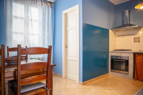 eine Küche mit einem Tisch und einer blauen Wand in der Unterkunft Solemar Sicilia - Casa Enza in Santa Flavia