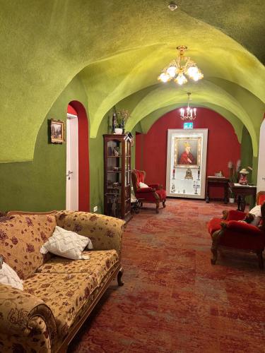 a living room with green and red walls and a couch at Hotel Garni Daniela Urich in Schwanenstadt