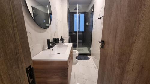 ein Badezimmer mit Waschbecken, Toilette und Spiegel in der Unterkunft Luxurious apartment with all comforts in El Pary