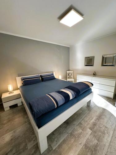 a bedroom with a large bed with blue sheets at Fewo Himmelblau in Burgen