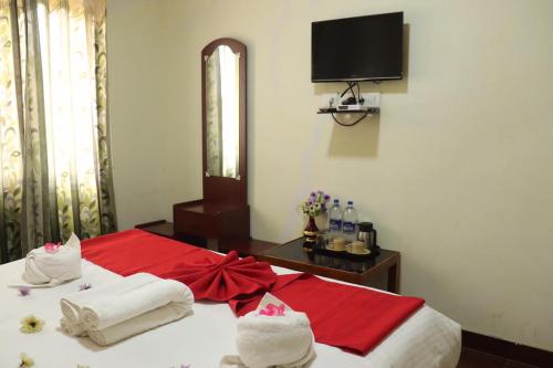 a bedroom with a bed with red and white towels at Life style home stay in Kodaikānāl