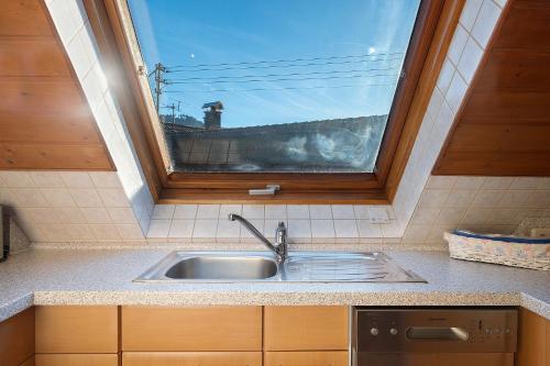 una cocina con fregadero y una ventana por encima. en Ferienwohnung Waldblick, en Simonswald