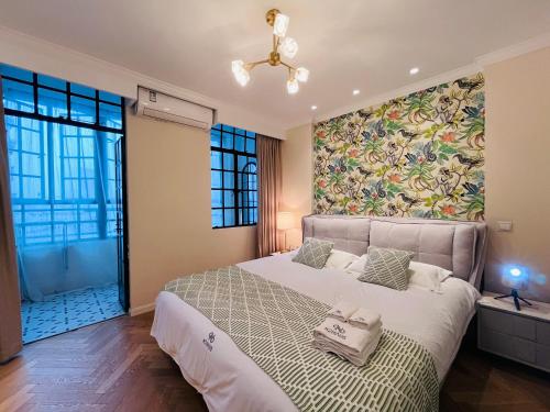 a bedroom with a large bed with a floral wall at 梧舍壹号 外滩百年公寓B&B -Riverside Grace Suites on the bund and metro station in Shanghai