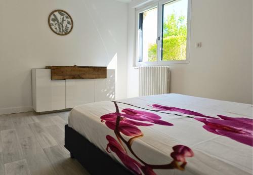 a bedroom with a bed with purple flowers on it at Appartement avec vue exceptionnelle in Blanzat