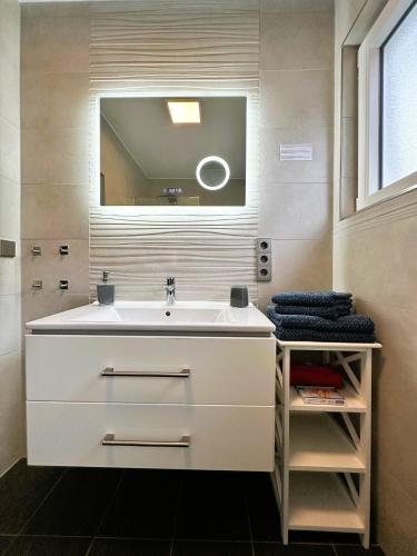a bathroom with a white sink and a mirror at Fewo Himmelblau in Burgen