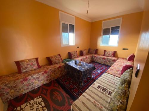 een woonkamer met banken en een tafel bij house surrounded by trees in a village in Tiznit
