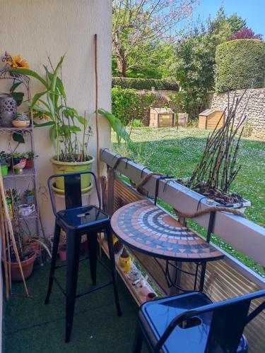 a patio with two chairs and a table and a bench at Cosy Coty in Tours