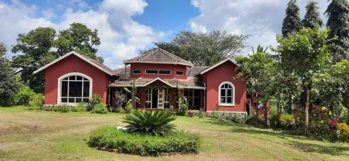 a red house with a large yard at Dandeli Chalet in Dandeli
