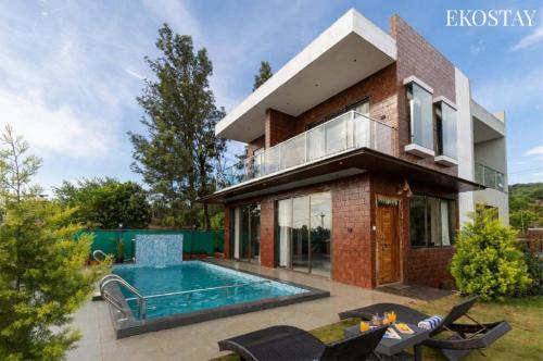 a house with a swimming pool in front of it at EKOSTAY - Terra Cotta Villa in Panchgani