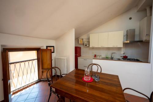 Defstero Asteri في ريجيو إيميليا: مطبخ مع طاولة وكراسي خشبية في الغرفة