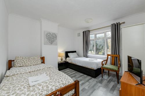 a bedroom with two beds and a television at The Victorian House Escape, Free Private Parking & Wifi, 7 beds in Colchester