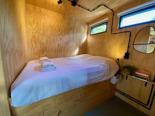 a small bed in a small room with a window at Tiny House The Cabin in Peize