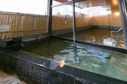a room with a pool of water with a chair in it at Ureshino Motoyu in Ureshino