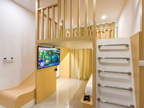 uma sala de estar com uma cama alta e uma televisão em D'Pristine Theme Suite by Nest Home at LEGOLAND em Nusajaya