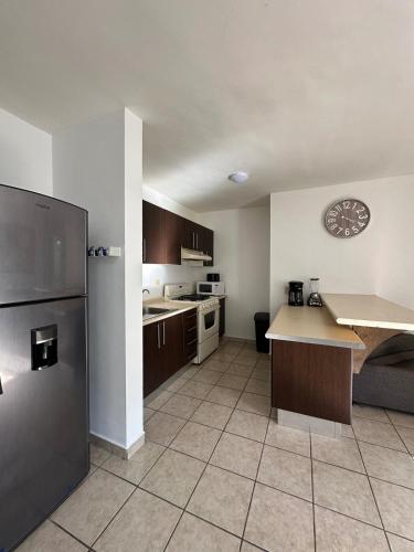 a small kitchen with a counter and a refrigerator at 3 beds 2 bath apartment minutes walk from the beach in Cabo San Lucas