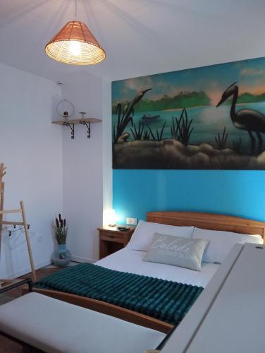 a bedroom with a bed with a painting on the wall at L'atelier du vélo in Sully-sur-Loire