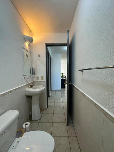 a bathroom with a white toilet and a sink at 3 beds 2 bath apartment minutes walk from the beach in Cabo San Lucas
