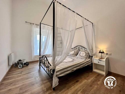 a bedroom with a bed with a canopy at Le gite aux oliviers in La Redorte