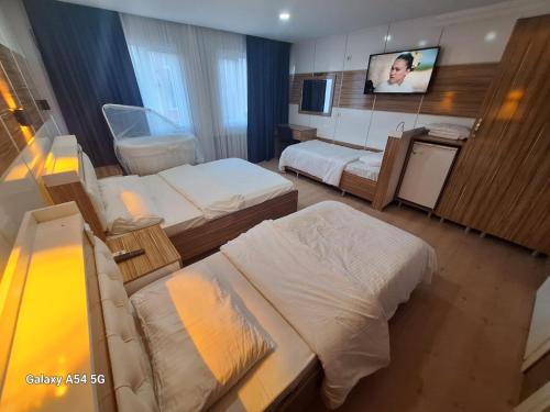 a hotel room with two beds and a flat screen tv at Dilmac Hotel in Gelibolu