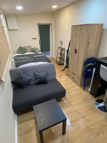a living room with two beds and a couch at Charming Cambridge Studio with Private Garden in Cherry Hinton