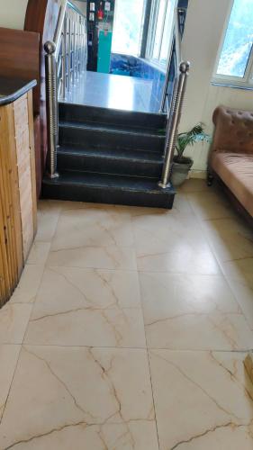 eine Lobby mit Treppe und Fliesenboden in der Unterkunft streem View in Masuri