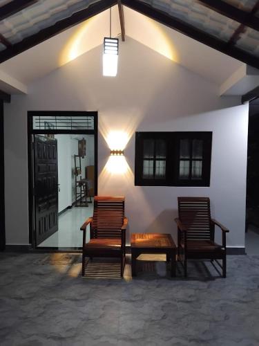 two chairs and a table in a room at The Hollyoak - Vintage Charm with Modern Comforts in Denipitiya