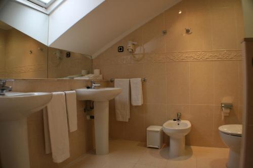 a bathroom with a sink and a toilet at Hotel Picos De Europa in Santander