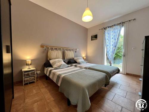 a bedroom with two beds and a window at Le gite du pech de saint jean in La Redorte