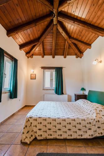 a bedroom with a large bed with a wooden ceiling at 4 εποχές in Kalavrita