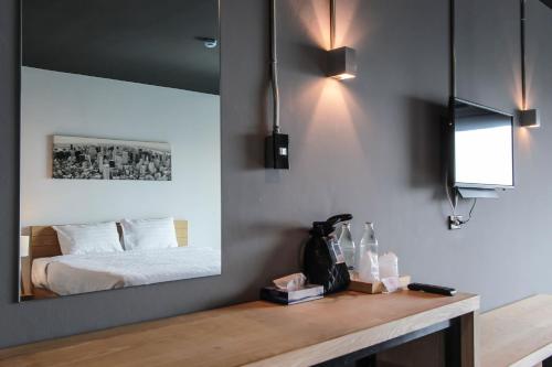 a bedroom with a bed and a mirror on the wall at Get Zleep Premium Budget Hotel in Chiang Mai